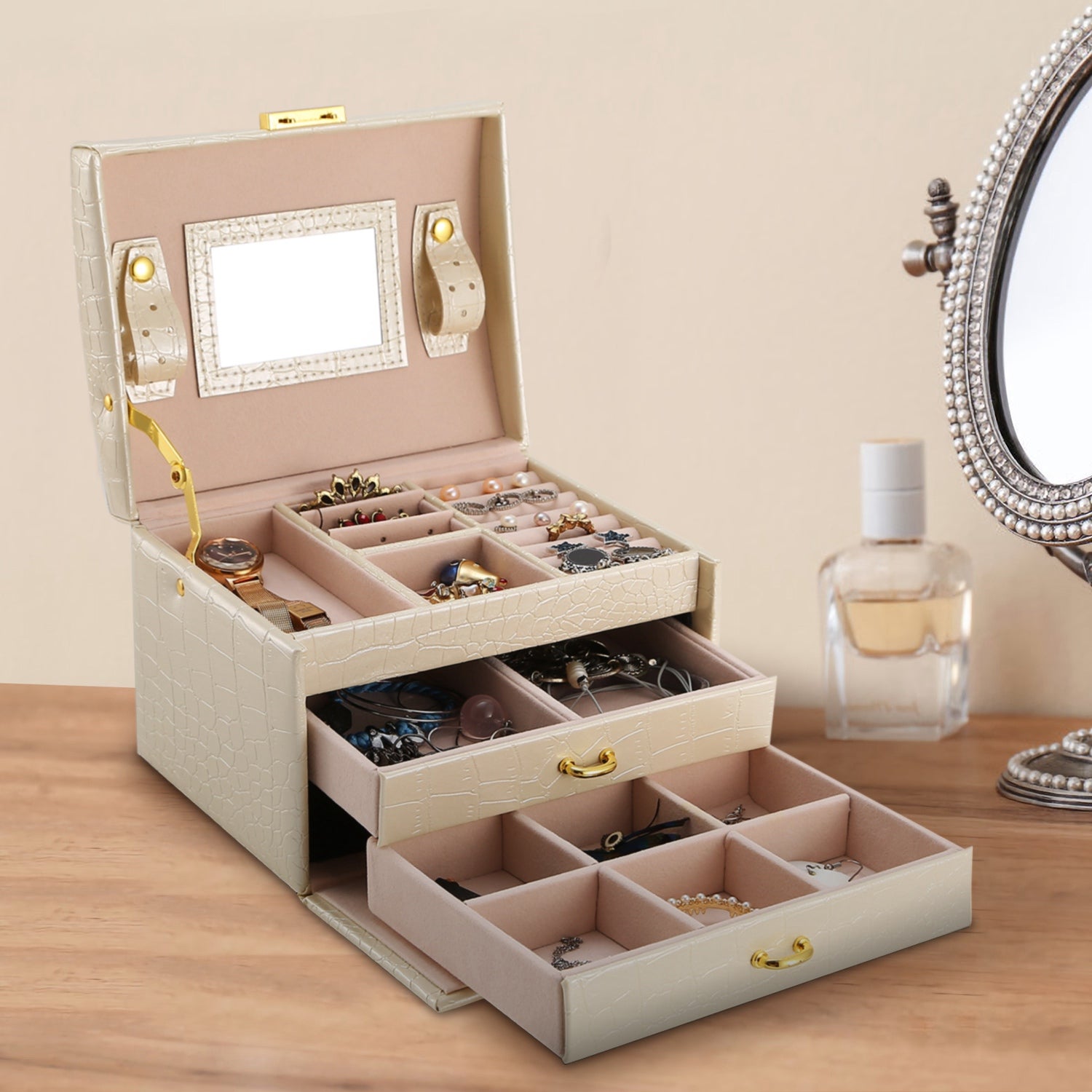 Three-layer lockable travel jewelry organizer box holding necklaces, rings, and earrings.